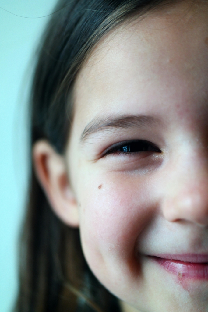 Delightful close-up of a young girl smiling, evoking happiness and innocence.