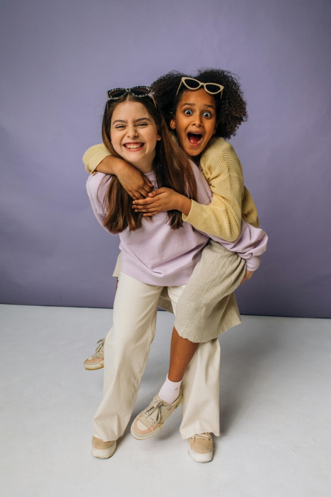 Two young girls share a playful piggyback ride, highlighting fun and friendship.